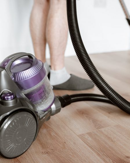 man vacuuming floor during household chores